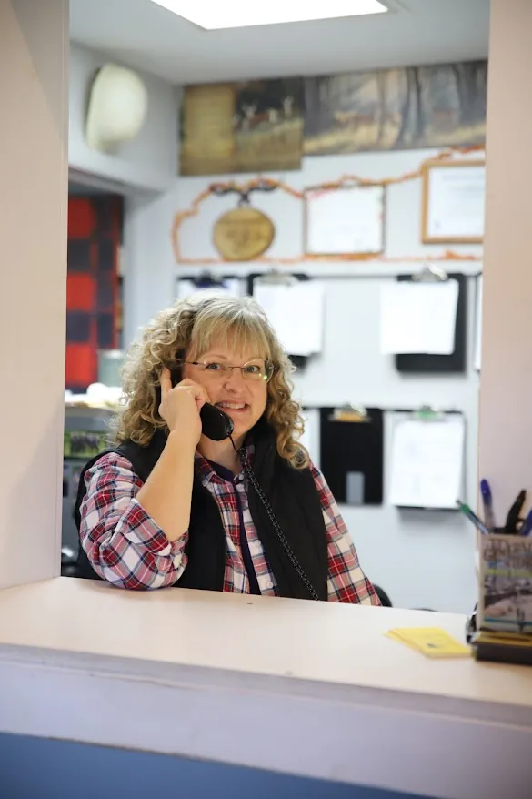 Chris taking a customer call at the shop counter